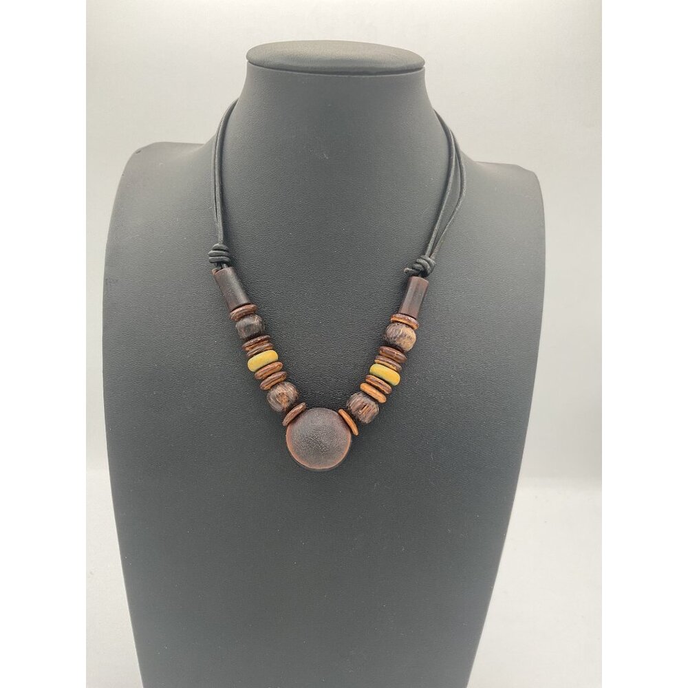chunky brown wooden beaded necklace with a large central disc pendant